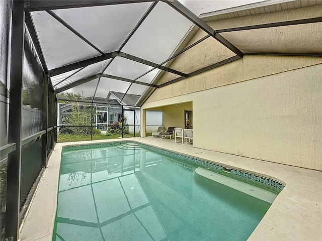 view of swimming pool featuring a patio and a lanai