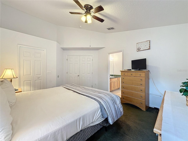 carpeted bedroom featuring a textured ceiling, connected bathroom, ceiling fan, and lofted ceiling