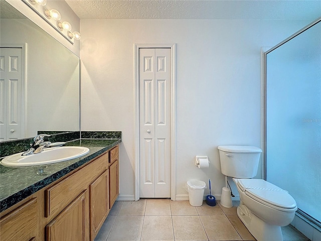 bathroom featuring vanity, tile patterned floors, toilet, a textured ceiling, and a shower with shower door