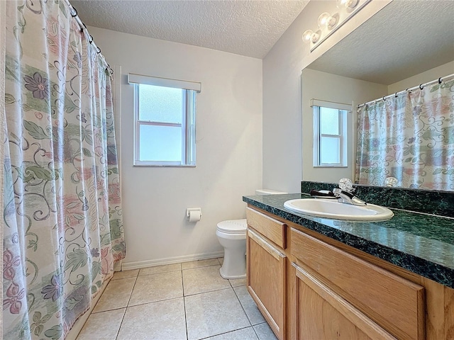 bathroom with tile patterned floors, plenty of natural light, a textured ceiling, and vanity