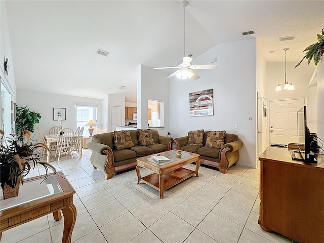 living room featuring ceiling fan with notable chandelier, high vaulted ceiling, and light tile patterned flooring