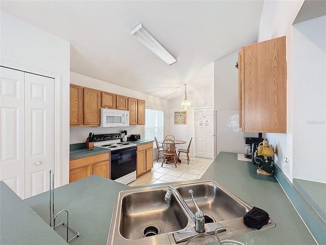 kitchen featuring sink, hanging light fixtures, vaulted ceiling, white appliances, and light tile patterned floors