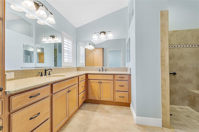 bathroom with vanity, lofted ceiling, and tiled shower