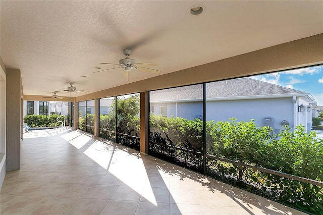 unfurnished sunroom featuring ceiling fan