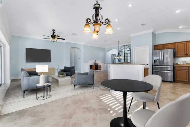 interior space featuring lofted ceiling, crown molding, ceiling fan with notable chandelier, and plenty of natural light