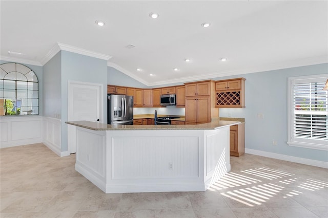 kitchen with lofted ceiling, light stone counters, ornamental molding, stainless steel appliances, and a kitchen island with sink