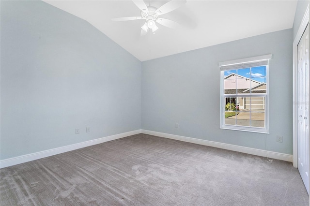 spare room with vaulted ceiling, light colored carpet, and ceiling fan