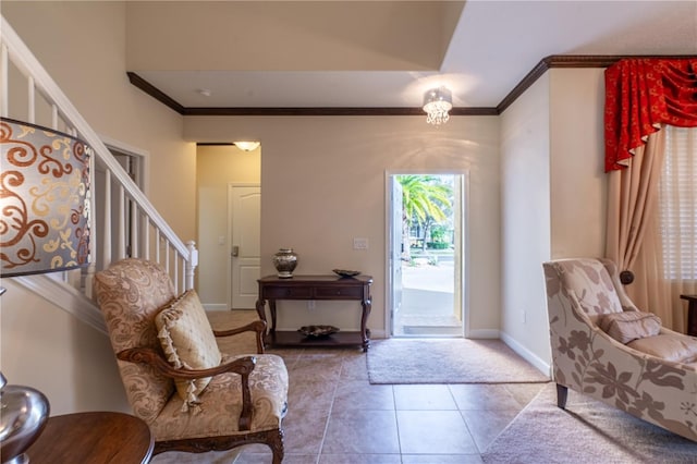 tiled entryway with a chandelier and ornamental molding