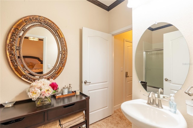 bathroom featuring tile patterned flooring, a shower with door, crown molding, and sink