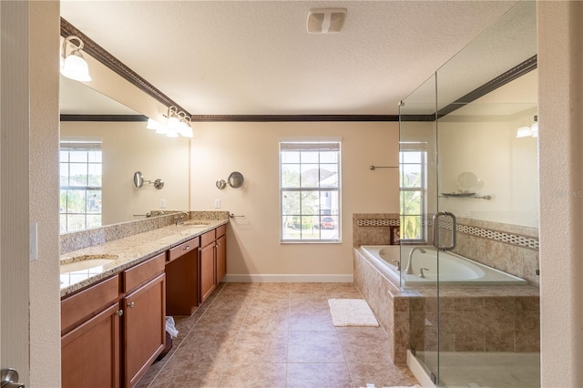 bathroom featuring a relaxing tiled tub, a healthy amount of sunlight, ornamental molding, and vanity