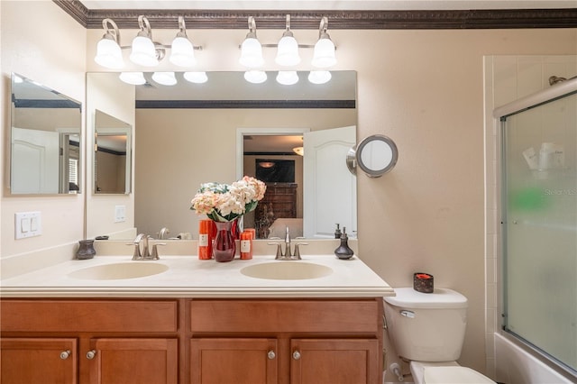 full bathroom with crown molding, vanity, bath / shower combo with glass door, and toilet