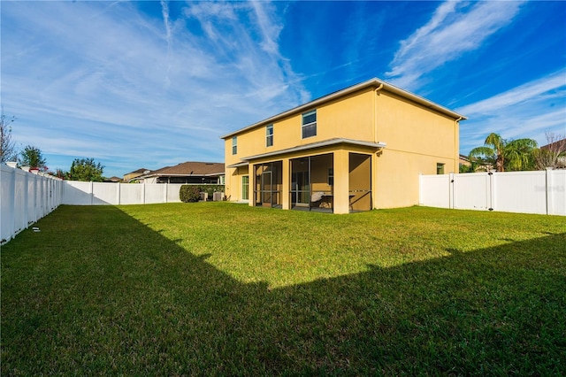 rear view of house with a sunroom and a yard