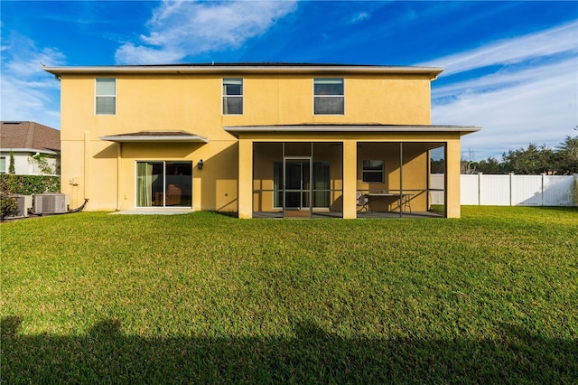 rear view of house with a lawn, a sunroom, and central air condition unit