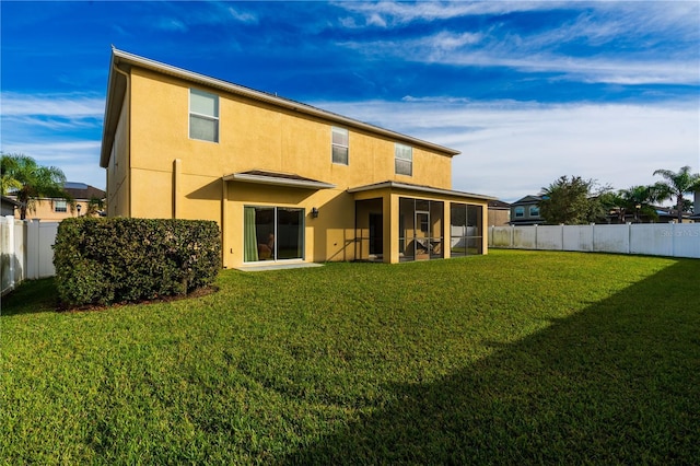 back of house featuring a lawn and a sunroom