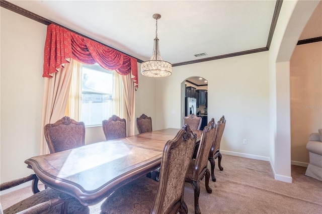 carpeted dining area featuring a chandelier and ornamental molding