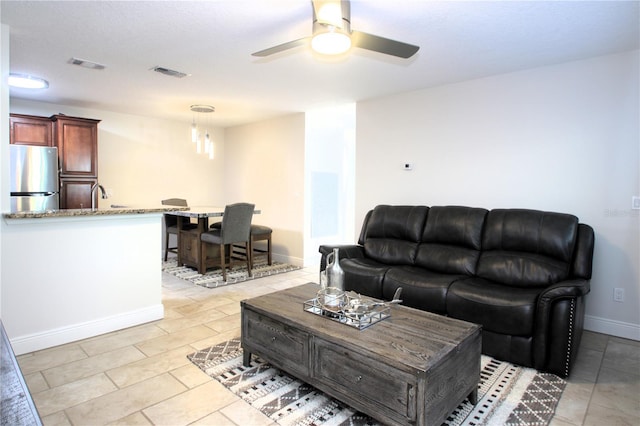 living room with ceiling fan and light tile patterned floors