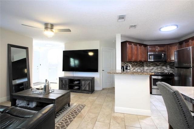 kitchen featuring decorative backsplash, ceiling fan, light tile patterned flooring, light stone counters, and stainless steel appliances