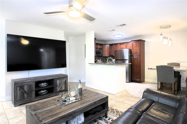 living room with ceiling fan, light tile patterned floors, and sink