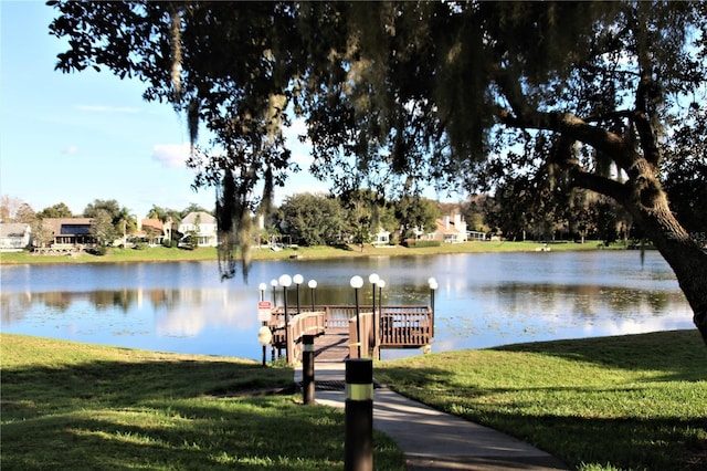 view of dock featuring a water view and a yard