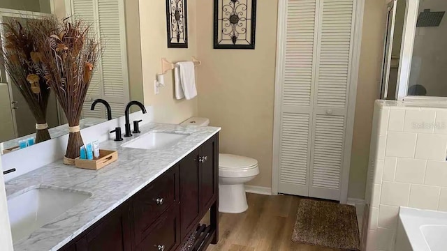 bathroom featuring wood-type flooring, vanity, and toilet