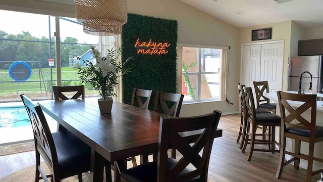 dining room with lofted ceiling and light wood-type flooring