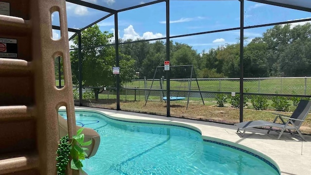 view of swimming pool featuring a lanai, a yard, and a patio