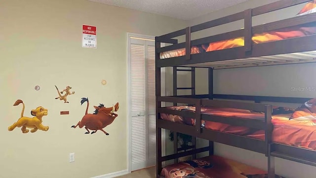 bedroom featuring a textured ceiling, carpet floors, and a closet