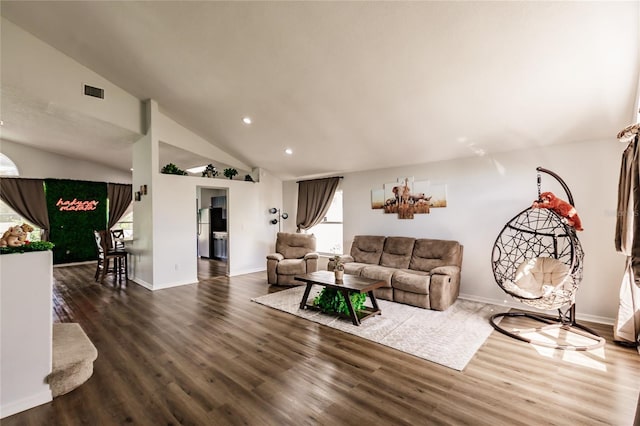 living room featuring vaulted ceiling, wood finished floors, visible vents, and baseboards