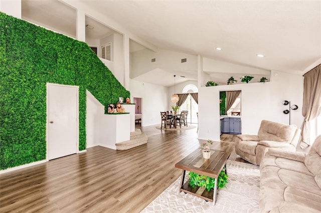 unfurnished living room with high vaulted ceiling, wood finished floors, visible vents, and recessed lighting