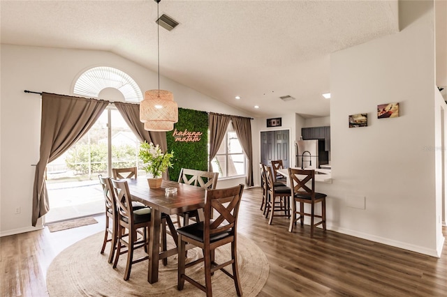 dining room featuring lofted ceiling, visible vents, and dark wood-type flooring