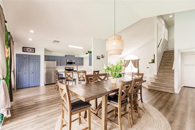 dining space with light wood-type flooring, stairs, and recessed lighting