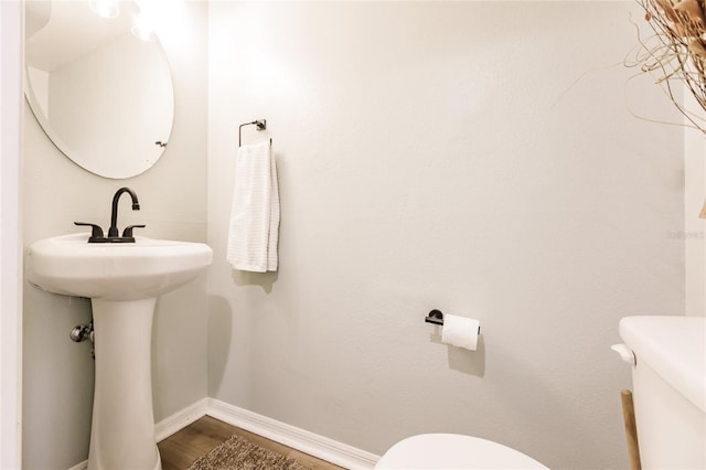 bathroom featuring baseboards, toilet, and wood finished floors