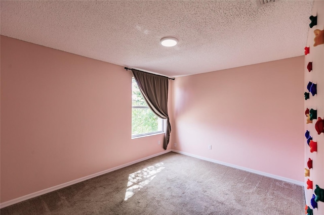 unfurnished room featuring a textured ceiling, carpet flooring, and baseboards