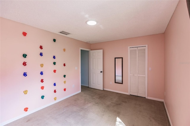 unfurnished bedroom featuring a closet, light colored carpet, visible vents, and baseboards