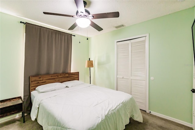 carpeted bedroom featuring ceiling fan, a textured ceiling, visible vents, baseboards, and a closet