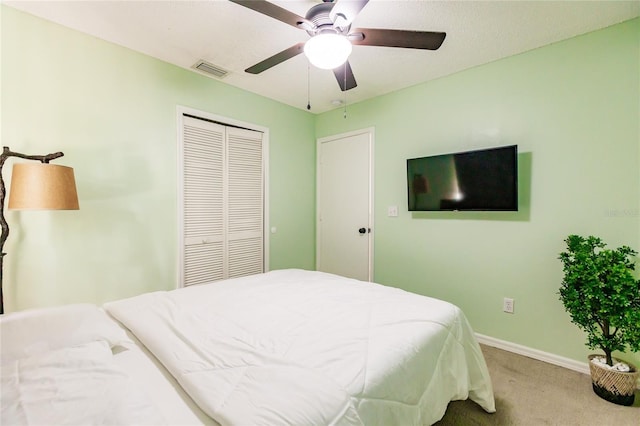 bedroom with baseboards, visible vents, ceiling fan, carpet floors, and a closet