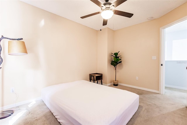 carpeted bedroom with ceiling fan and baseboards