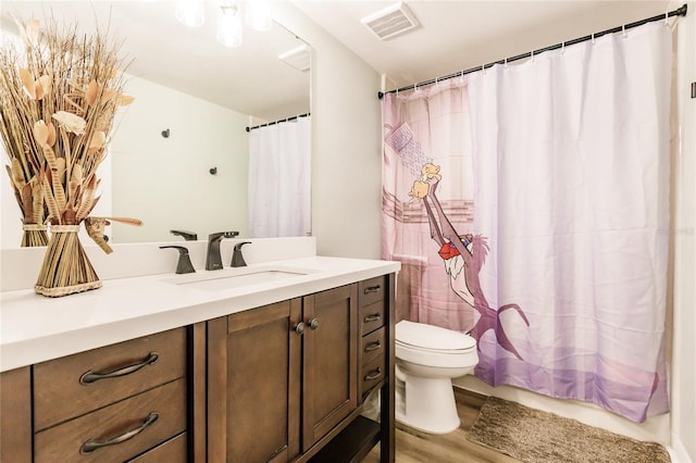 bathroom featuring visible vents, toilet, a shower with curtain, wood finished floors, and vanity