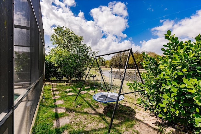 view of yard featuring a trampoline and fence