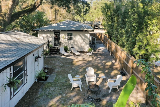 rear view of house featuring an outdoor fire pit