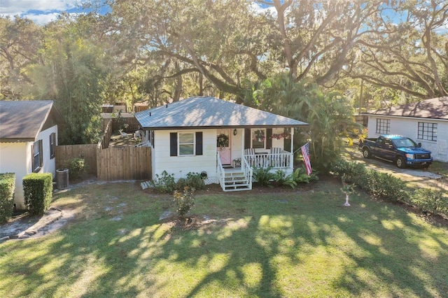 single story home featuring covered porch, central air condition unit, and a front lawn