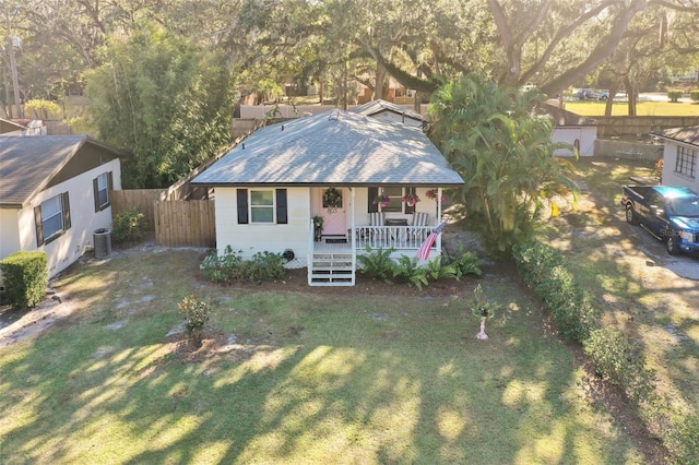 view of front of property with a front yard, a porch, and cooling unit