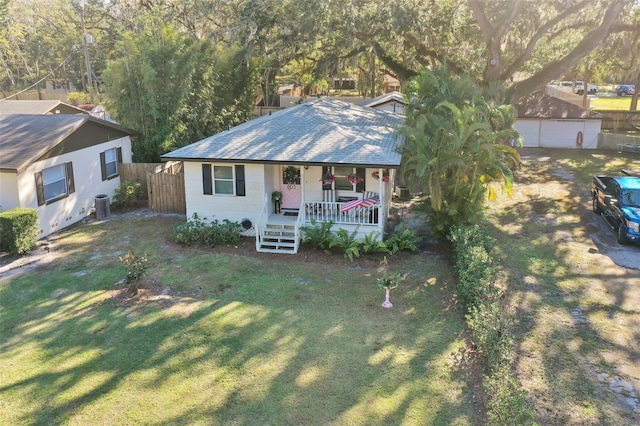 view of front of property featuring covered porch, an outbuilding, central AC, and a front lawn