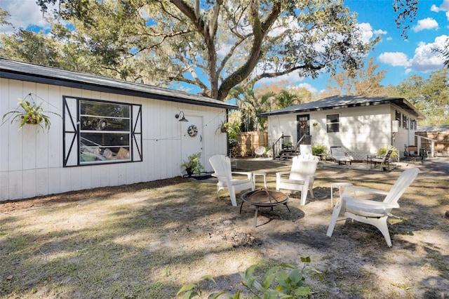 rear view of house featuring a patio area and a fire pit