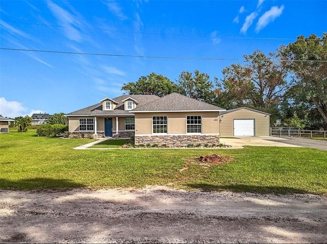 view of front of house featuring an outbuilding, a front lawn, and a garage