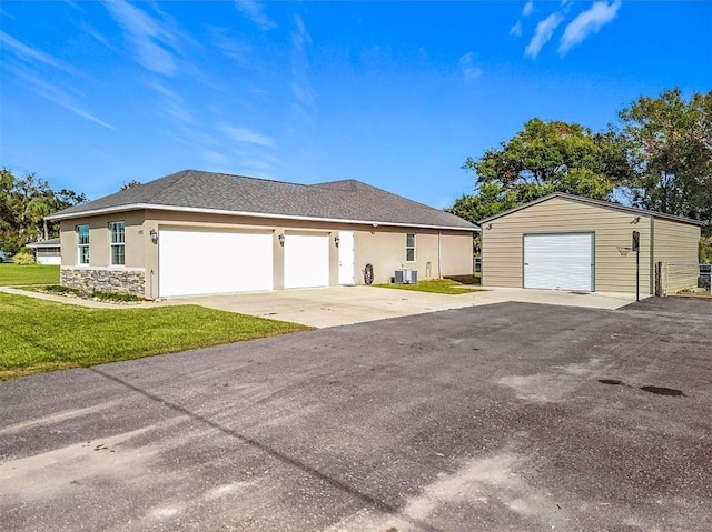 view of front of house featuring a front yard, ac unit, and a garage