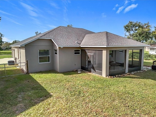 rear view of property featuring a sunroom, a yard, and central air condition unit