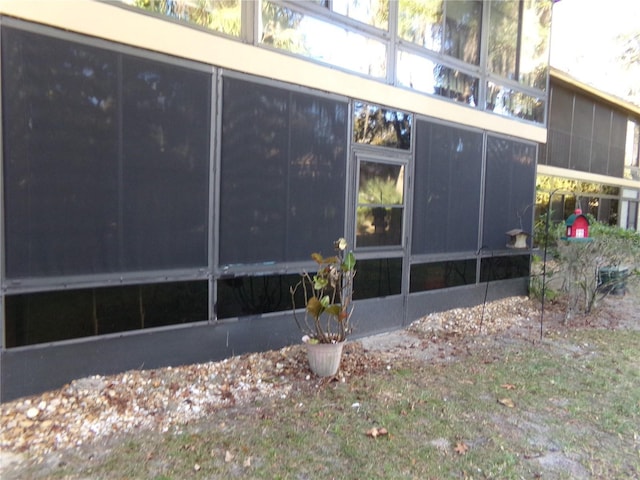 view of property exterior with a sunroom