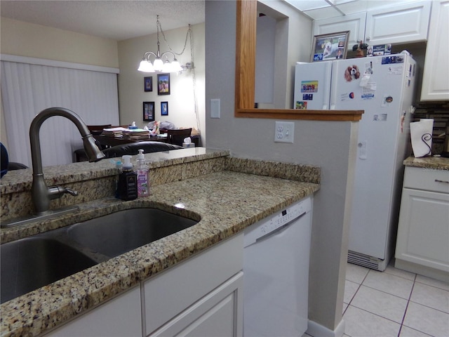 kitchen featuring white appliances, sink, a notable chandelier, white cabinetry, and hanging light fixtures