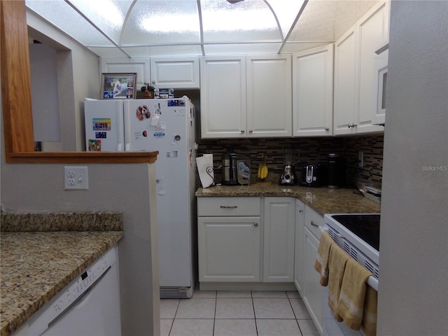 kitchen with tasteful backsplash, white cabinetry, and range